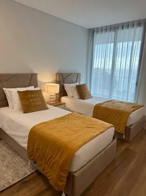 two beds in a hotel room with windows at Deluxe Bay View in Câmara de Lobos