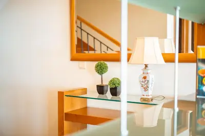 a glass table with two plants and a lamp on it at Palm Tree House by Amazing Madeira in Câmara de Lobos