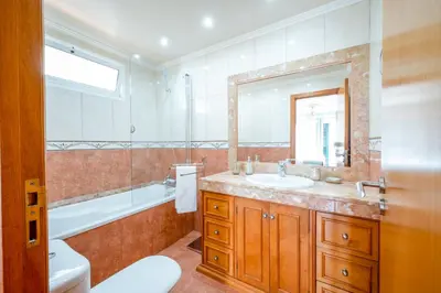 a bathroom with a sink and a tub and a toilet at Palm Tree House by Amazing Madeira in Câmara de Lobos
