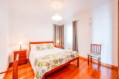 a bedroom with a bed and a chair at Palm Tree House by Amazing Madeira in Câmara de Lobos