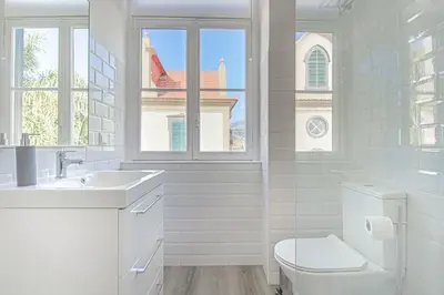 a white bathroom with a toilet and a sink at Pi Houses in Funchal