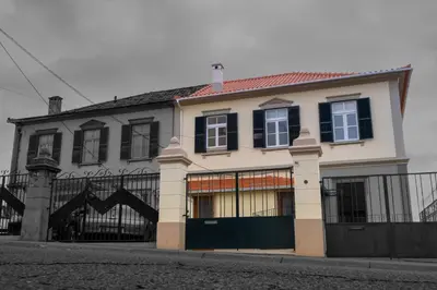 a large white house with a black fence at Pi Houses in Funchal
