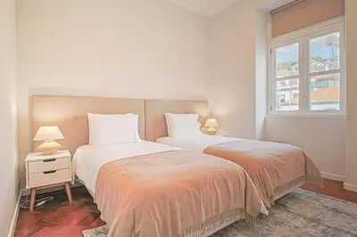 two beds in a bedroom with a window at Pi Houses in Funchal