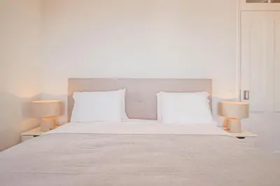 a bedroom with a large white bed with two lamps at Pi Houses in Funchal