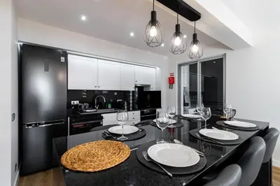 a kitchen with a black table and black chairs at Barreiros Holidays by Atlântica in Funchal