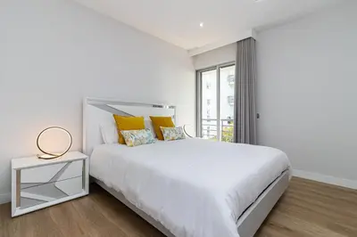 a white bedroom with a white bed and a window at Barreiros Holidays by Atlântica in Funchal