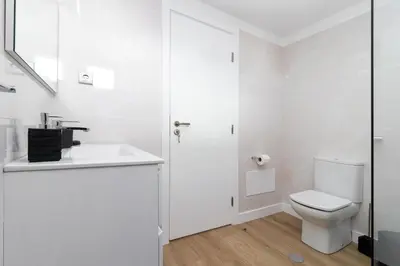 a white bathroom with a toilet and a sink at Barreiros Holidays by Atlântica in Funchal