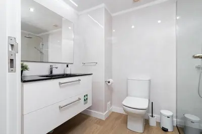 a white bathroom with a toilet and a sink at Barreiros Holidays by Atlântica in Funchal