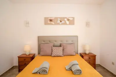 a bedroom with a bed with two lamps and two towels at Casa da Tia in Luz