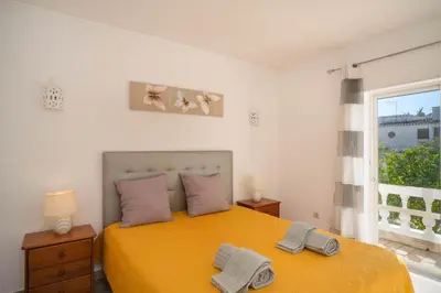 a bedroom with a yellow bed with two towels on it at Casa da Tia in Luz
