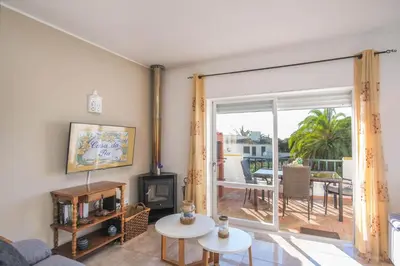a living room with a fireplace and a large sliding glass door at Casa da Tia in Luz