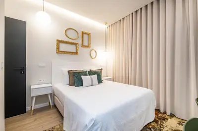 a bedroom with a large white bed and curtains at Machim D Arfet House by Homie in Machico