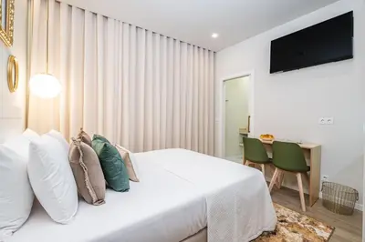 a bedroom with a white bed and a table and chairs at Machim D Arfet House by Homie in Machico
