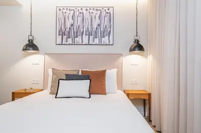 a bedroom with a large white bed with two lamps at Machim D Arfet House by Homie in Machico
