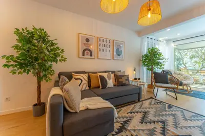a living room with a couch and a tree in it at FLH Funchal Spacious Apartment with Balcony in Funchal