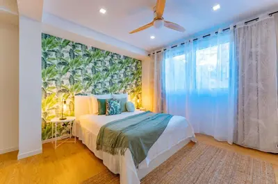 a bedroom with a bed and a large window at FLH Funchal Spacious Apartment with Balcony in Funchal