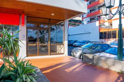 a store front with glass doors and parked cars at FLH Funchal Spacious Apartment with Balcony in Funchal