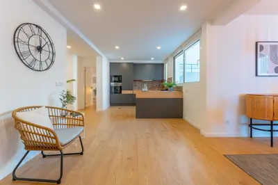 a living room with a table and a clock on the wall at FLH Funchal Spacious Apartment with Balcony in Funchal