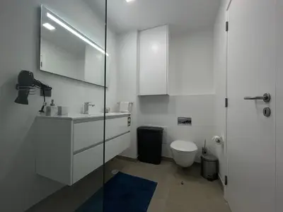 a white bathroom with a sink and a toilet at Sea and Sun 4 You - Jardins da Imperatriz in Funchal