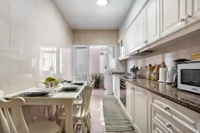 a kitchen with a table with chairs and a microwave at Central Living Funchal in Funchal