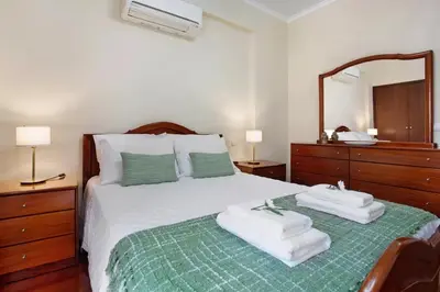 a bedroom with a bed with two towels on it at Central Living Funchal in Funchal