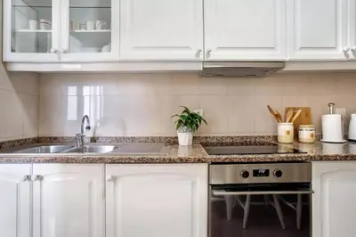 a kitchen with white cabinets and a sink at Central Living Funchal in Funchal