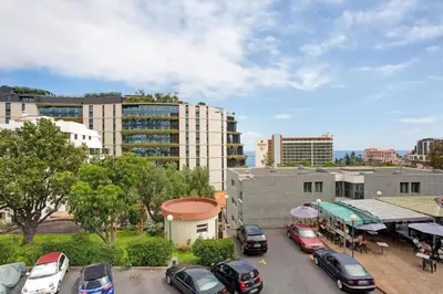a parking lot with cars parked in a city at Central Living Funchal in Funchal