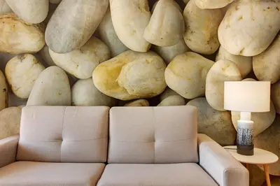 a living room with a couch and a wall of rocks at Casa do Calhau in Câmara de Lobos