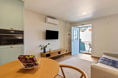 a living room with a table and a couch at Casa das Andorinhas in Câmara de Lobos