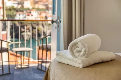 a hotel room with towels on a bed with a balcony at Casa das Andorinhas in Câmara de Lobos