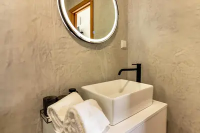a bathroom with a shower and a sink and a mirror at Casa das Andorinhas in Câmara de Lobos
