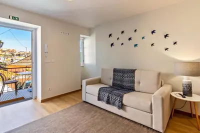 a living room with a chair and a window at Casa das Andorinhas in Câmara de Lobos