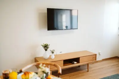 a living room with a tv on the wall at Casa do Calhau - 1 bedroom apartment sleeps 4 in Câmara de Lobos