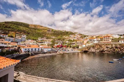 a town on a hill with a river and houses at Casa do Calhau - 1 bedroom apartment sleeps 4 in Câmara de Lobos