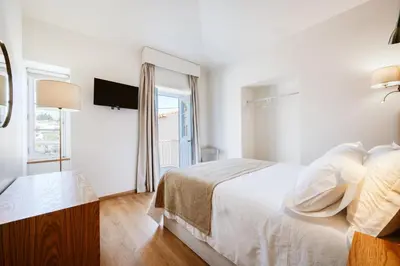 a white bedroom with a bed and a window at Casa do Calhau - 1 bedroom apartment sleeps 4 in Câmara de Lobos