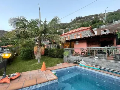 a swimming pool in front of a house at Secluded cottage w pool, oceanside view, 3BR, 3BA in Ponta do Sol