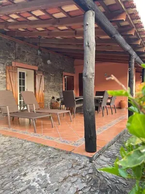 a patio with chairs and a table on a building at Secluded cottage w pool, oceanside view, 3BR, 3BA in Ponta do Sol