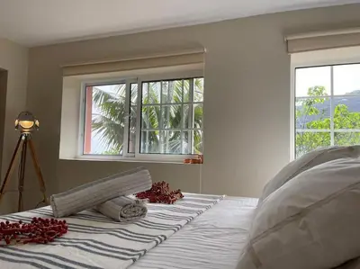 a white bedroom with a bed with a window at Secluded cottage w pool, oceanside view, 3BR, 3BA in Ponta do Sol