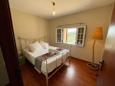 a bedroom with a bed and a lamp and a window at Secluded cottage w pool, oceanside view, 3BR, 3BA in Ponta do Sol