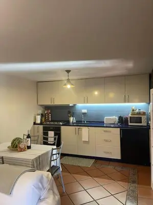 a kitchen with white cabinets and a table with a microwave at Secluded cottage w pool, oceanside view, 3BR, 3BA in Ponta do Sol