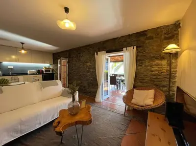 a living room with a white couch and a table at Secluded cottage w pool, oceanside view, 3BR, 3BA in Ponta do Sol