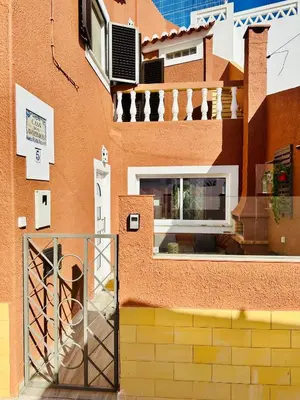 a living room with a table and chairs and a fireplace at Casa dos Avózinhos, Praia da Luz in Luz