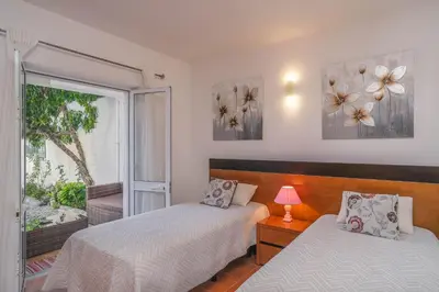 a bedroom with two beds and a window at Casa Caravela, Praia da Luz in Luz