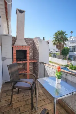 a patio with a fireplace and a table and chairs at Casa Caravela, Praia da Luz in Luz