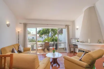 a living room with a fireplace and a table at Casa Caravela, Praia da Luz in Luz