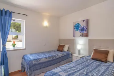 a bedroom with two beds and a window at Casa Caravela, Praia da Luz in Luz