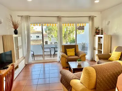 a living room with a couch and a tv and a table at Casa Caravela, Praia da Luz in Luz