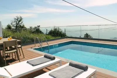 a swimming pool on top of a building with a table and chairs at Stunning Funchal Villa 3 Bedrooms Vila Da Portada Panoramic Sea Views in Funchal