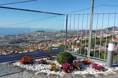 a flower bed on a balcony with a view of the city at Stunning Funchal Villa 3 Bedrooms Vila Da Portada Panoramic Sea Views in Funchal