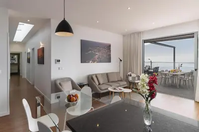 a living room and dining room with a table and chairs at Stunning Funchal Villa 3 Bedrooms Vila Da Portada Panoramic Sea Views in Funchal